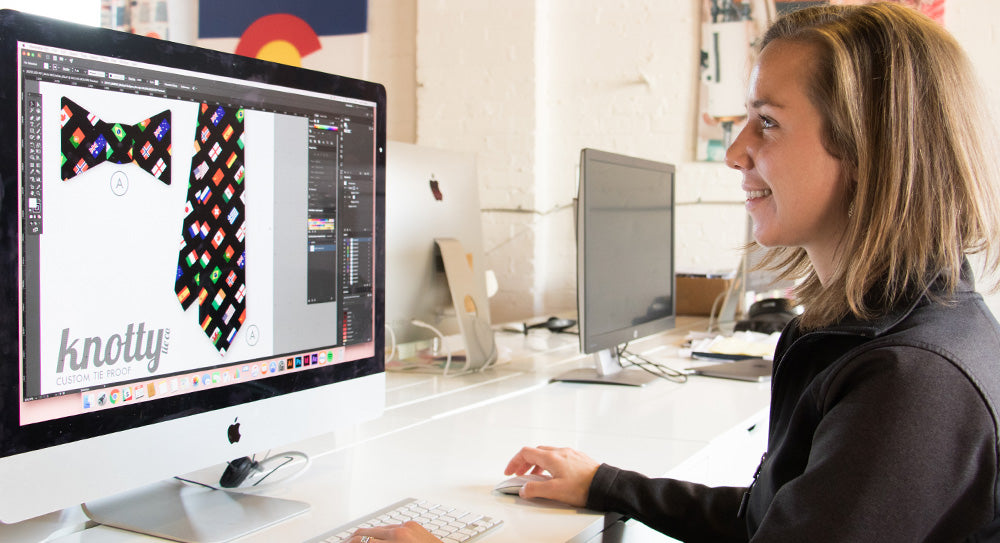 designer sitting at computer working on custom necktie designs