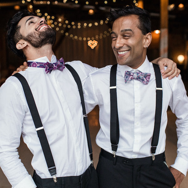 two men wearing bow ties and suspenders laughing