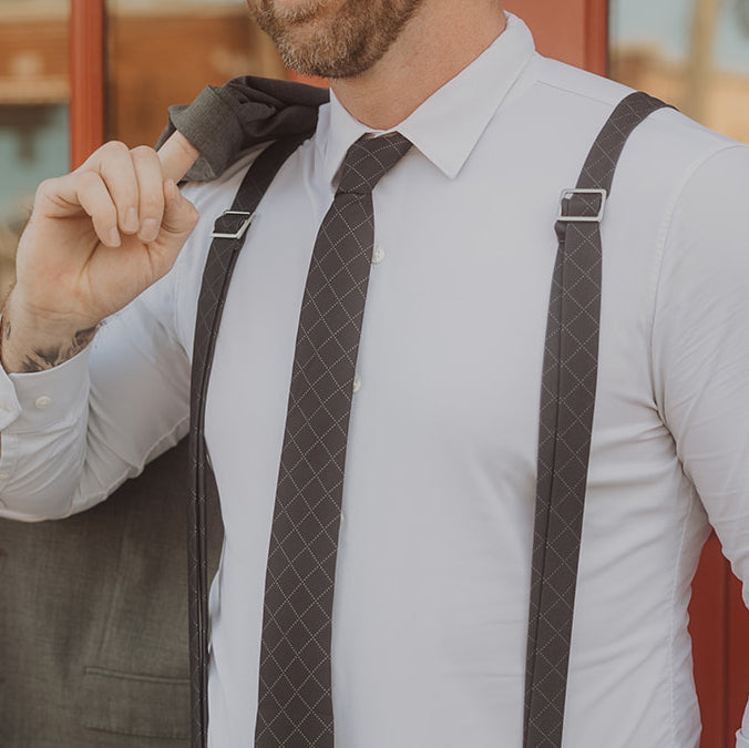 photo of man wearing matching black tie and suspenders